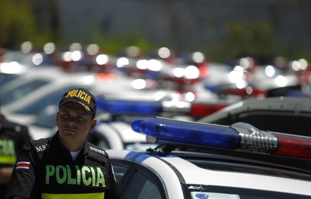 A police officer stands near some of the 150 police patrol cars donated by the Chinese government, outside the Children Museum in San Jose